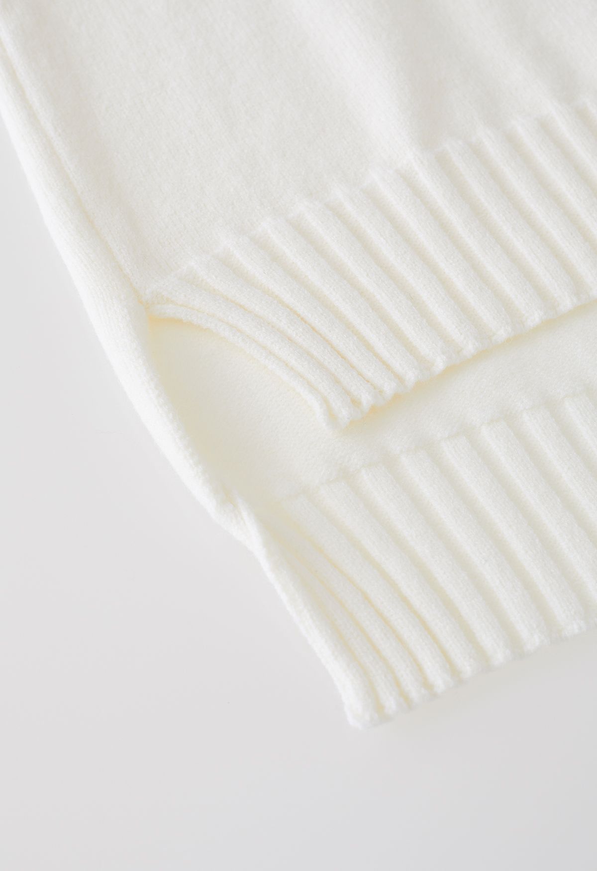 Conjunto de suéter gola alta com abotoamento e calça de malha em creme
