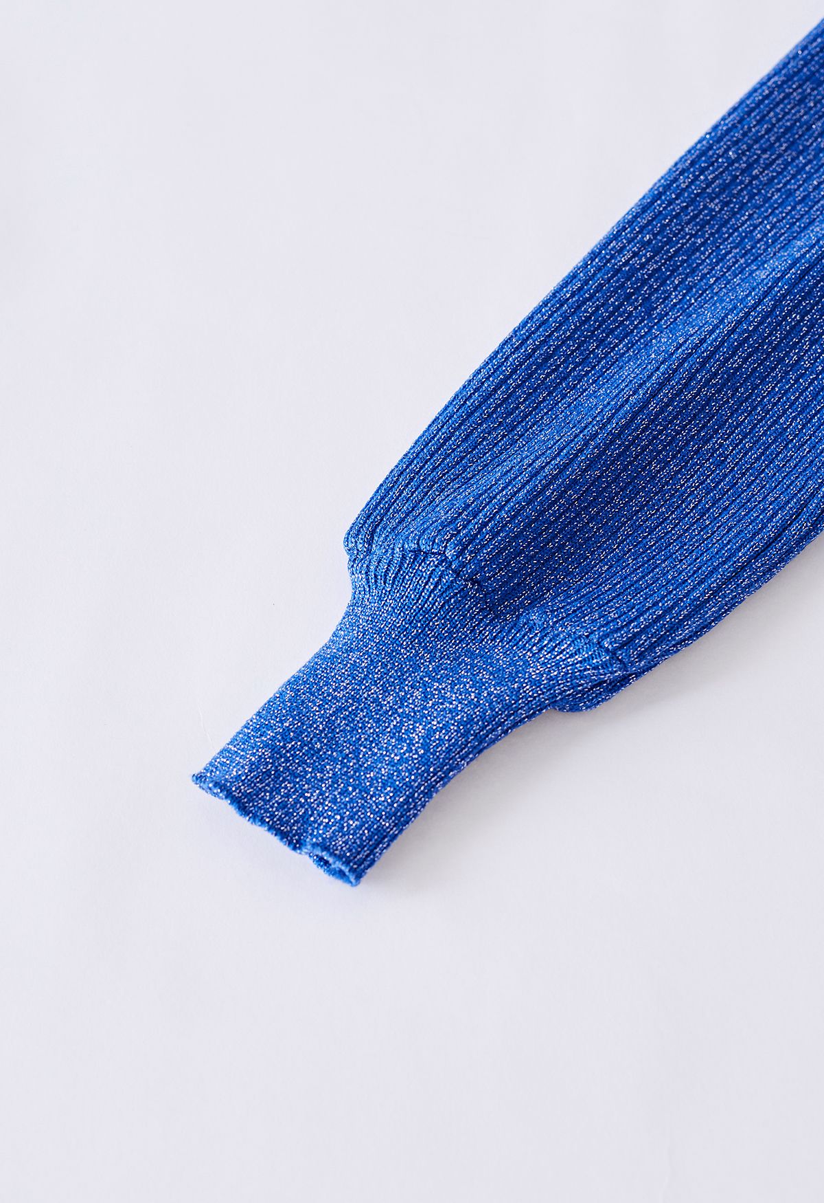 Top com nervuras brilhantes e conjunto de malha com saia plissada em azul