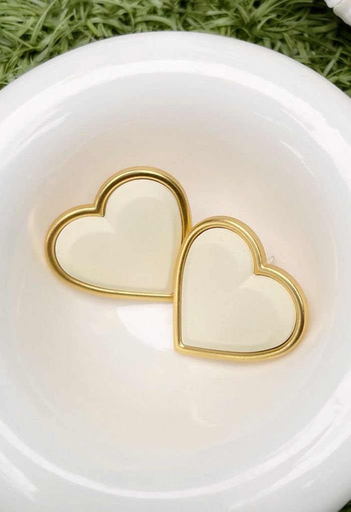 Brincos em formato de coração com acabamento dourado